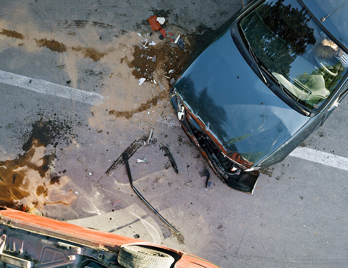 Overhead view of a car accident on a road, showing wreckage and debris from two damaged vehicles.